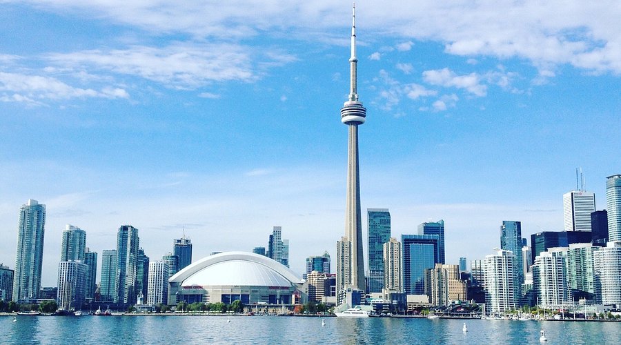 CN Tower skyline with a large building and a dome